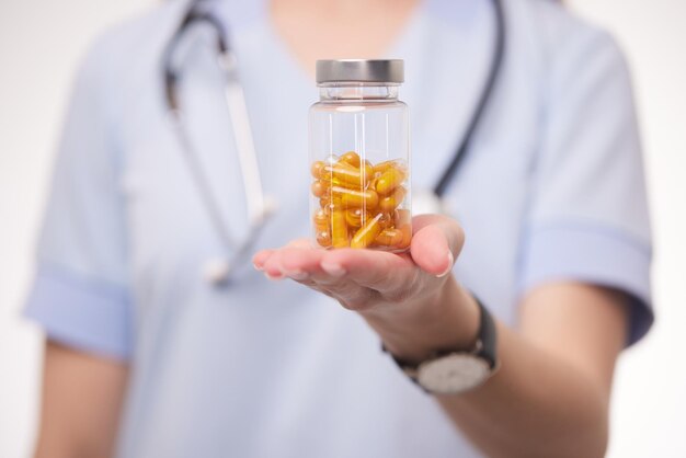 Doctor sosteniendo una pastilla transparente en sus manos de cerca