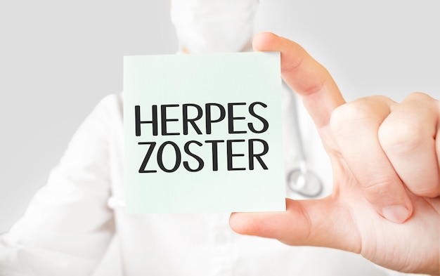 Doctor sosteniendo la tarjeta en las manos y apuntando la palabra HERPES ZOSTER