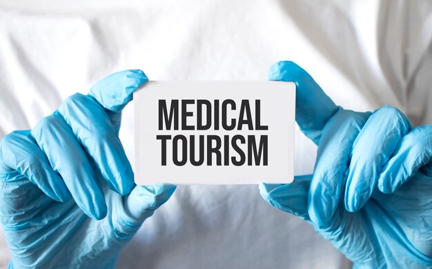 Doctor sosteniendo una tarjeta con texto turismo médico, concepto médico