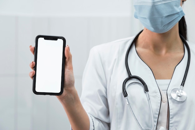 Doctor sosteniendo un teléfono en blanco