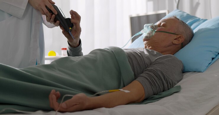 Doctor sosteniendo una terminal de pago para un paciente anciano acostado en la cama del hospital y pagando con tarjeta de crédito