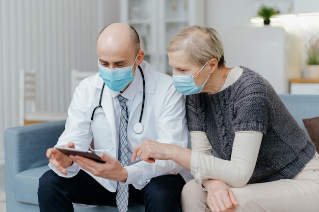 Doctor con una tableta digital está consultando a su paciente