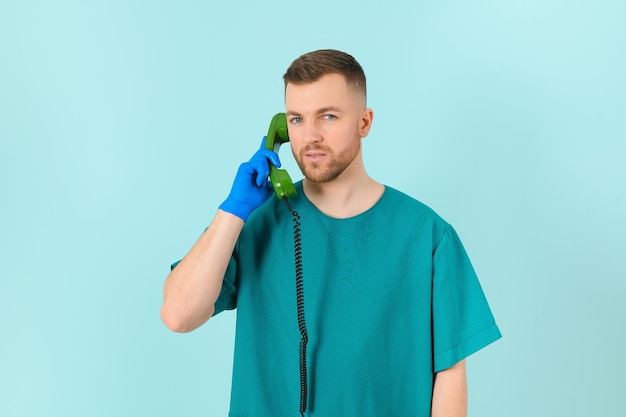 Doctor con teléfono en un concepto de llamada de médico de fondo azul