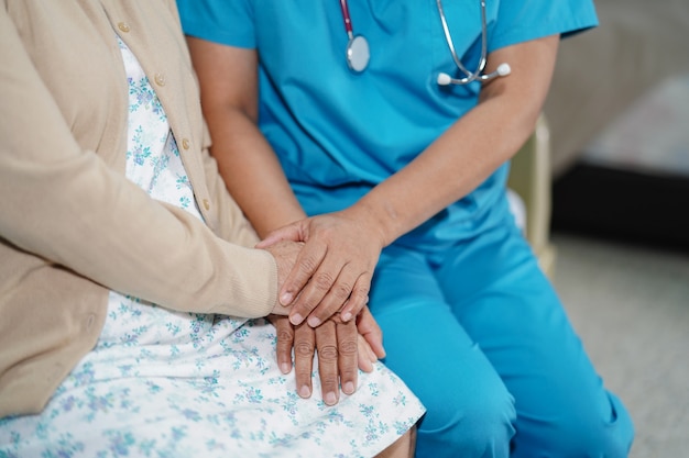 Doctor tocando las manos Paciente mujer asiática senior con amor.