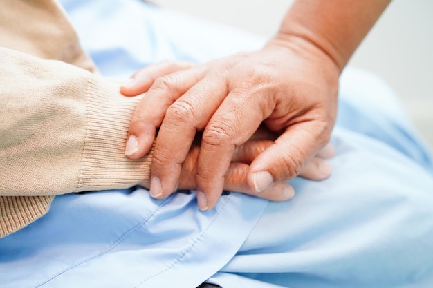 Doctor tomados de la mano Asia anciana paciente ayuda y atención en el hospital