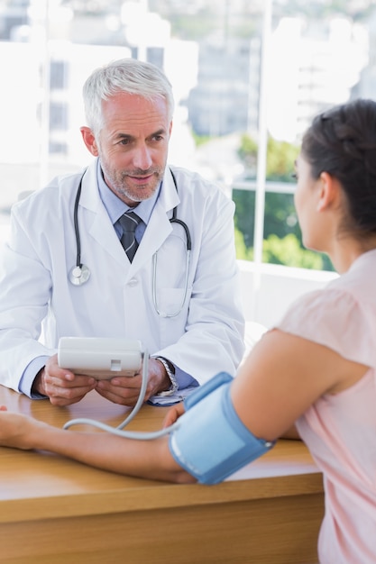 Doctor tomando latidos del corazón de un paciente femenino