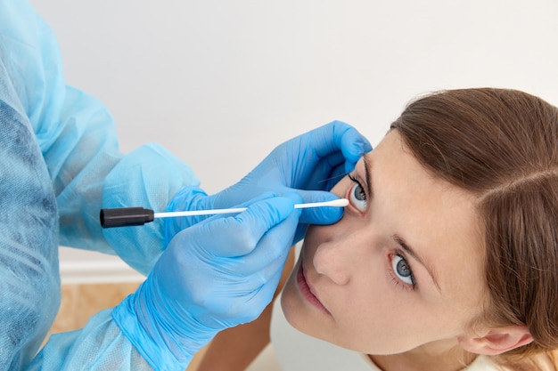 Doctor tomando muestra con hisopo del ojo