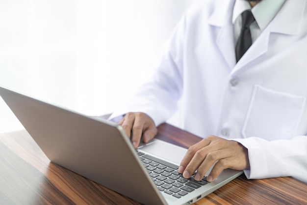 Doctor trabajando con computadora portátil en la oficina del hospital Concepto médico saludable