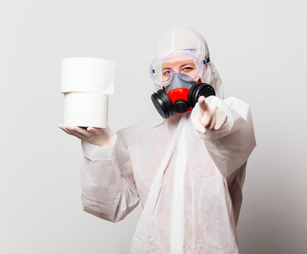 Doctor en traje de protección y gafas con máscara sostiene papel higiénico