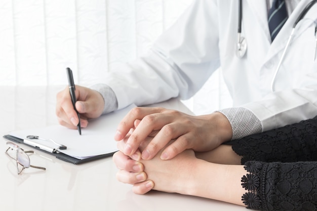 Doctor tranquilizando a su paciente femenino