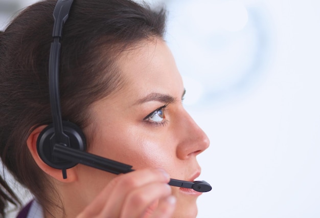 Doctor usando auriculares sentado detrás de un escritorio con una computadora portátil