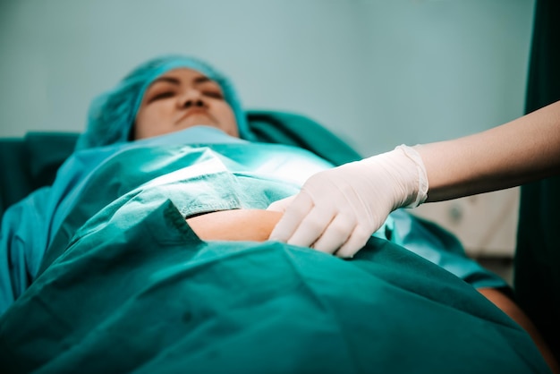Doctor usando una mano para sostener la grasa abdominal de pacientes obesas