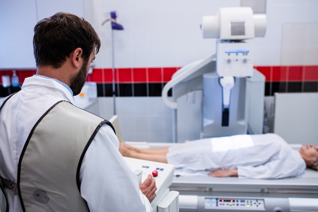 Doctor usando una máquina de rayos X para examinar al paciente