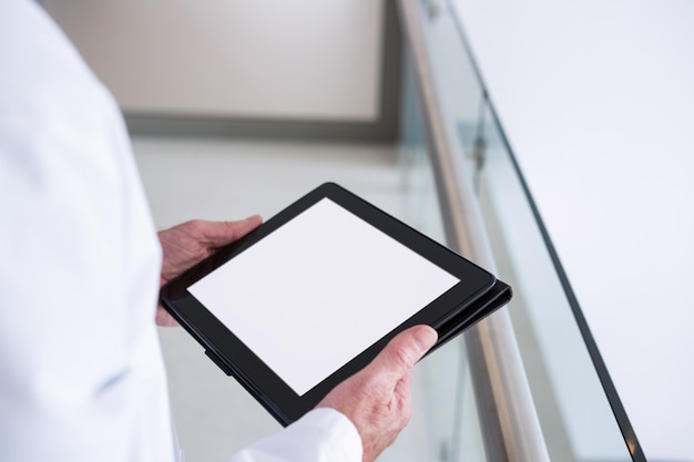 Doctor usando una tableta digital en el pasillo del hospital