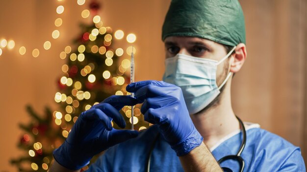 Doctor con vacuna sobre fondo de Navidad