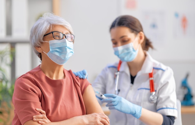 Doctor vacunando a una mujer mayor Protección contra virus COVID2019