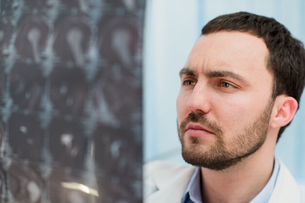 Doctor viendo radiografía por resonancia magnética del cerebro en el consultorio