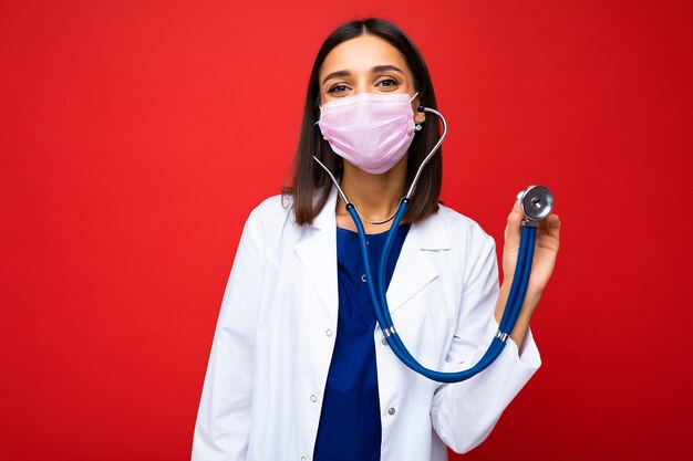 Doctor vistiendo una máscara médica y un estetoscopio aislado sobre fondo