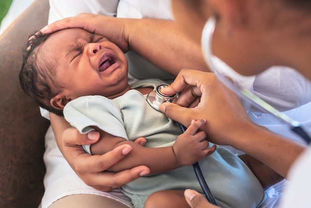 Doctora africana usando un estetoscopio revisando el sistema respiratorio y los latidos del corazón