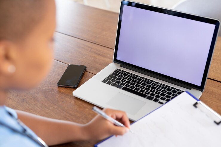 Foto doctora afroamericana dando consulta por videollamada usando una computadora portátil, copiando espacio en la pantalla