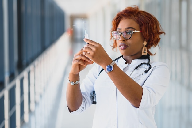 Doctora afroamericana con jeringa con inyección