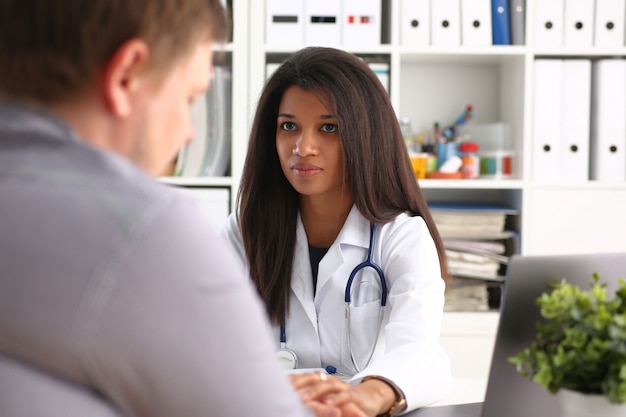 Doctora amable con paciente masculino