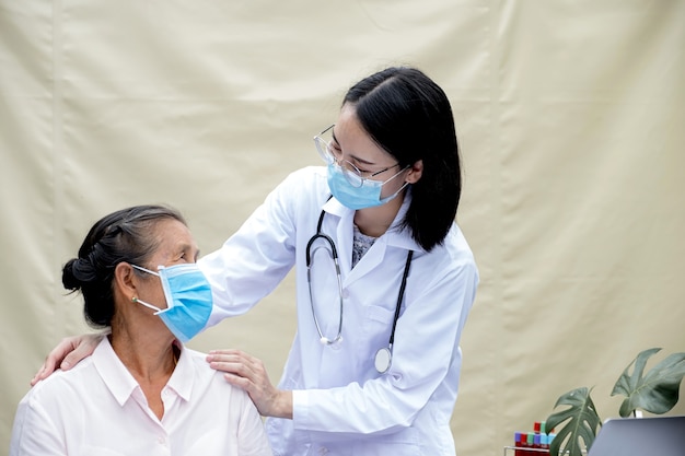 La doctora apoya a los pacientes en los hombros de los ancianos y guía la atención médica amigable.