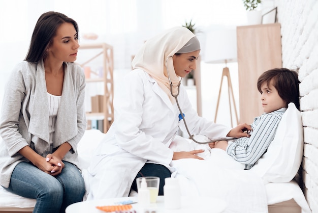 Doctora árabe examinando a un niño pequeño