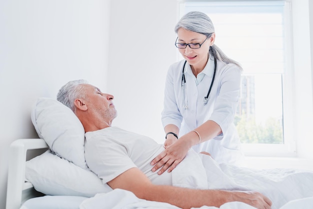 Doctora asiática consolando al paciente en la sala del hospital