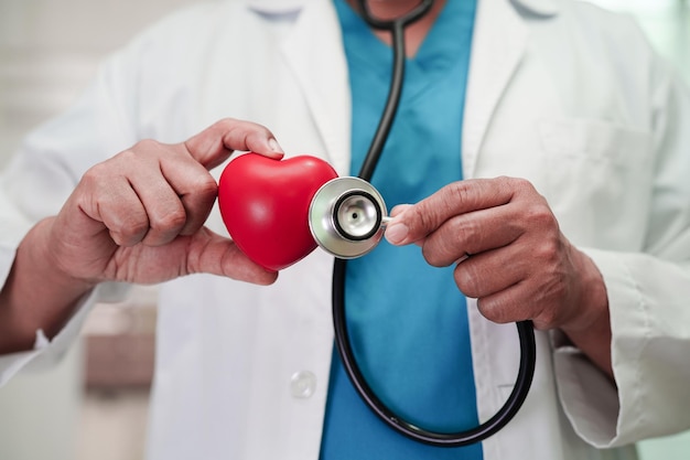 Doctora asiática con corazón rojo para la salud en el hospital