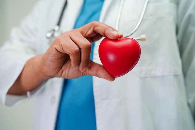 Doctora asiática con corazón rojo para la salud en el hospital