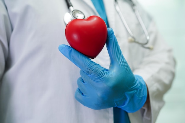 Doctora asiática con corazón rojo para la salud en el hospital