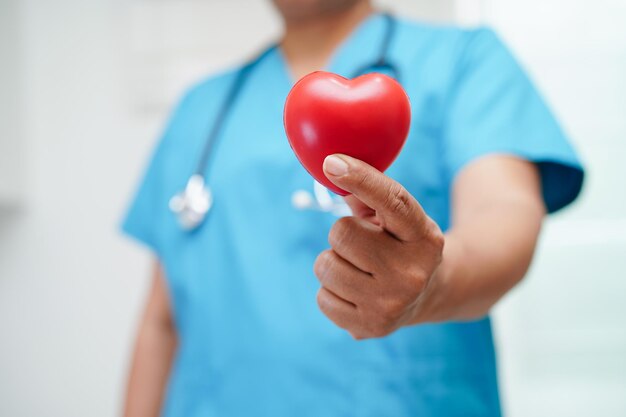 Foto doctora asiática con corazón rojo para la salud en el hospital