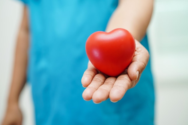 Doctora asiática con corazón rojo para la salud en el hospital