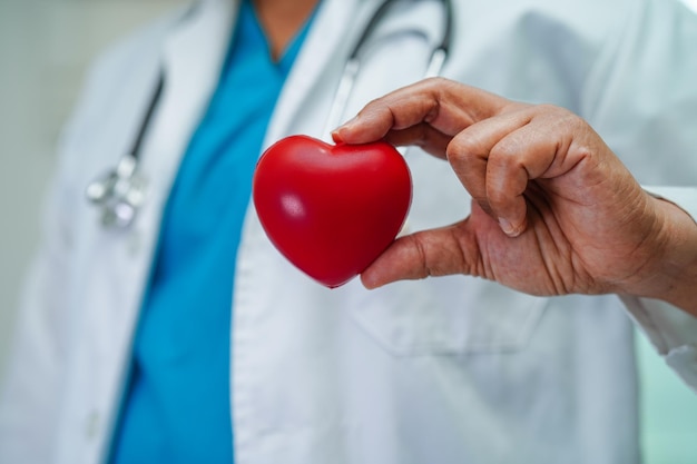 Doctora asiática con corazón rojo para la salud en el hospital