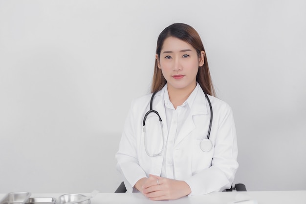 Doctora asiática mirando directamente al hospital con una bata blanca