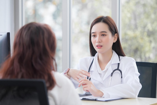 La doctora asiática profesional sugiere una solución sanitaria a su paciente anciano en la sala de examen