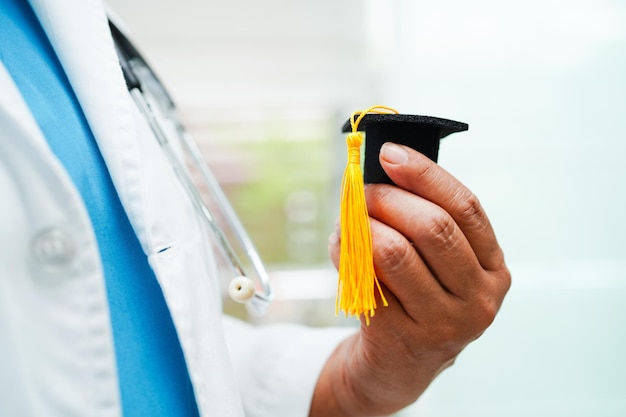 Doctora asiática con sombrero de graduación en el hospital Concepto de educación médica