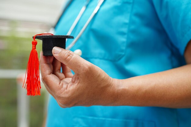 Doctora asiática con sombrero de graduación en el hospital Concepto de educación médica