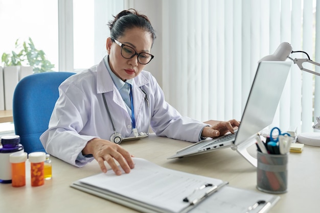 Doctora asiática trabajando en oficina