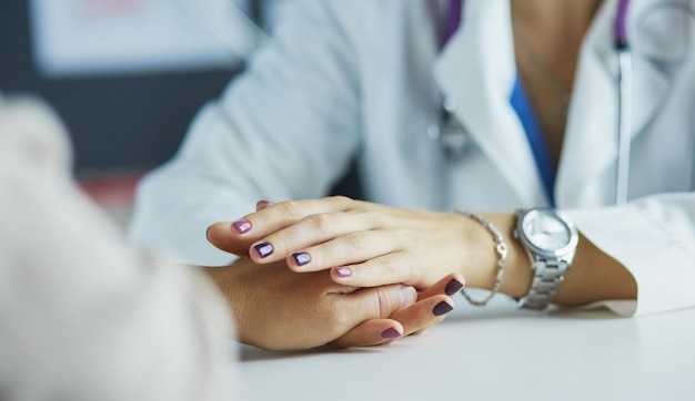 Doctora ayudando a senior de la mano en el hospital