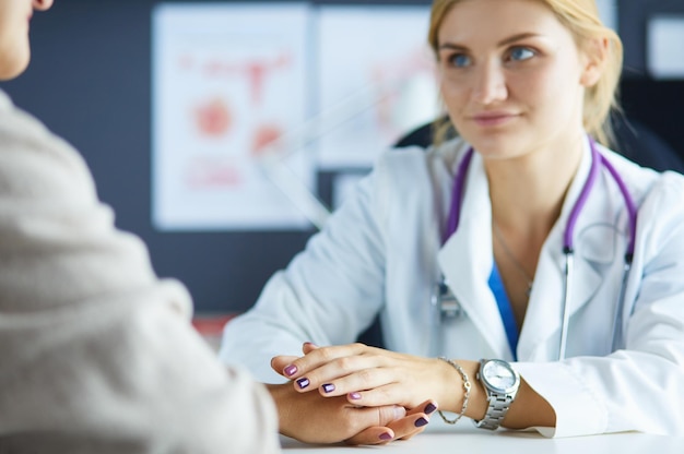 Doctora ayudando a senior de la mano en el hospital