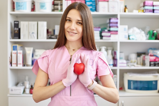 Doctora con bata rosa y guantes de látex