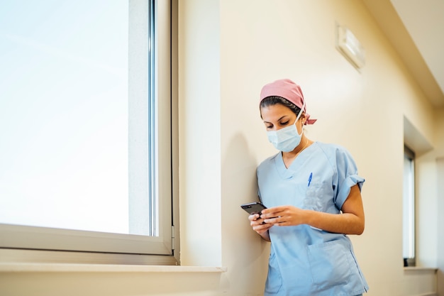 Doctora cirujano utilizando teléfonos inteligentes