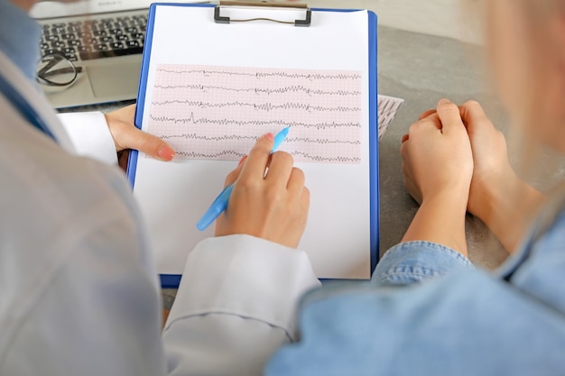 Doctora comprobando los resultados del electrocardiograma con el paciente