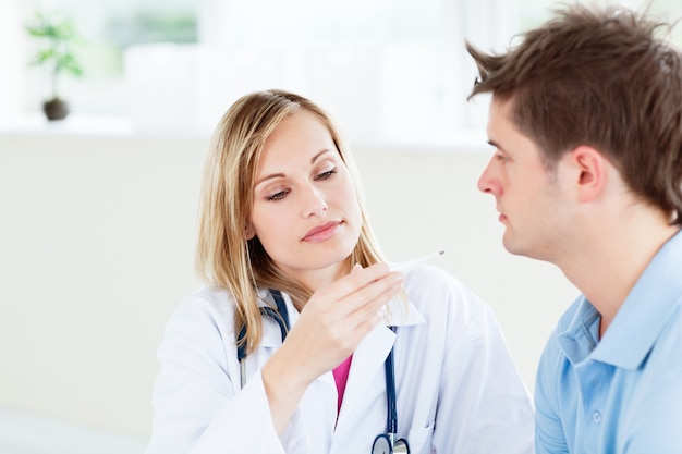 doctora concentrada mirando la temperatura del paciente