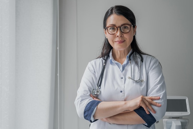 Una doctora confiada parada en la oficina y sonriendo a la cámara