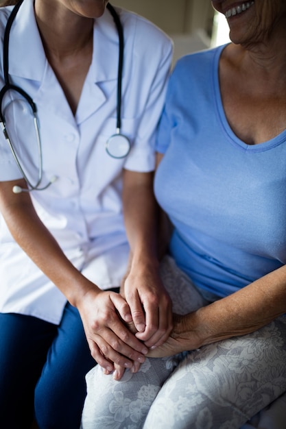 Foto doctora consolando a la mujer mayor en el dormitorio