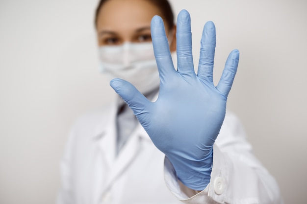 Foto una doctora de enfermedades infecciosas en una máscara protectora y guantes médicos