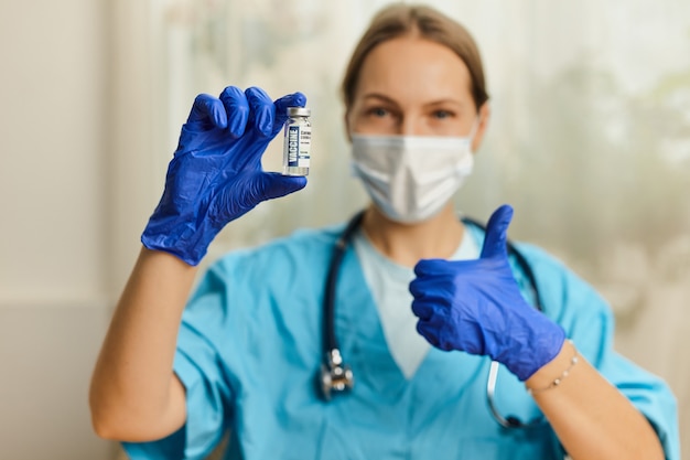 Doctora, enfermera, científica con estetoscopio, con guantes azules con coronavirus, enfermedad de la vacuna covid-19 que se prepara para la vacunación, la medicina y el concepto de fármaco.